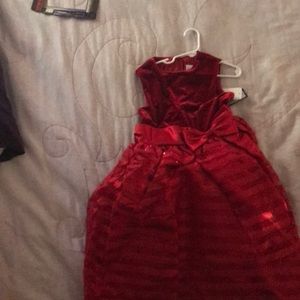 This kids dress is pretty, red, and formal.